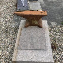 Gravsten til smeden med en ambolt som dekoration udført i Rød Svensk Granit