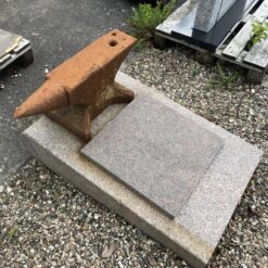 Gravsten til smeden med en ambolt som dekoration udført i Rød Svensk Granit