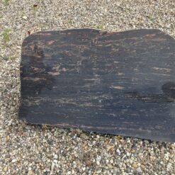 Gravsten i natursten mørk med brunlige åre