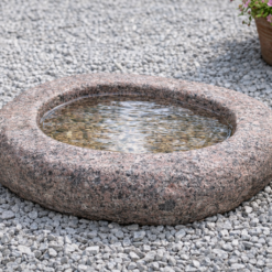 Granit fuglebad i massiv natursten med organisk form – håndbearbejdet fuglebad i rosa granit til have og terrasse